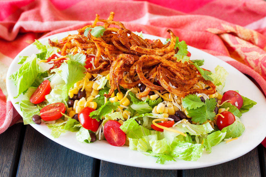 Crispy spiralized potato tossed in a taco seasoned sauce makes for a no-dressing-needed salad.