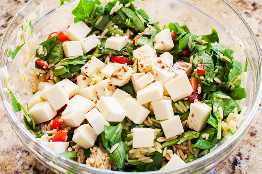 Classic caprese ingredients (basil, mozzarella, tomatoes, and balsamic vinaigrette) modernized into a salad with spinach and orzo pasta.