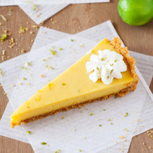 Slice of mango key lime tart on parchment paper. 