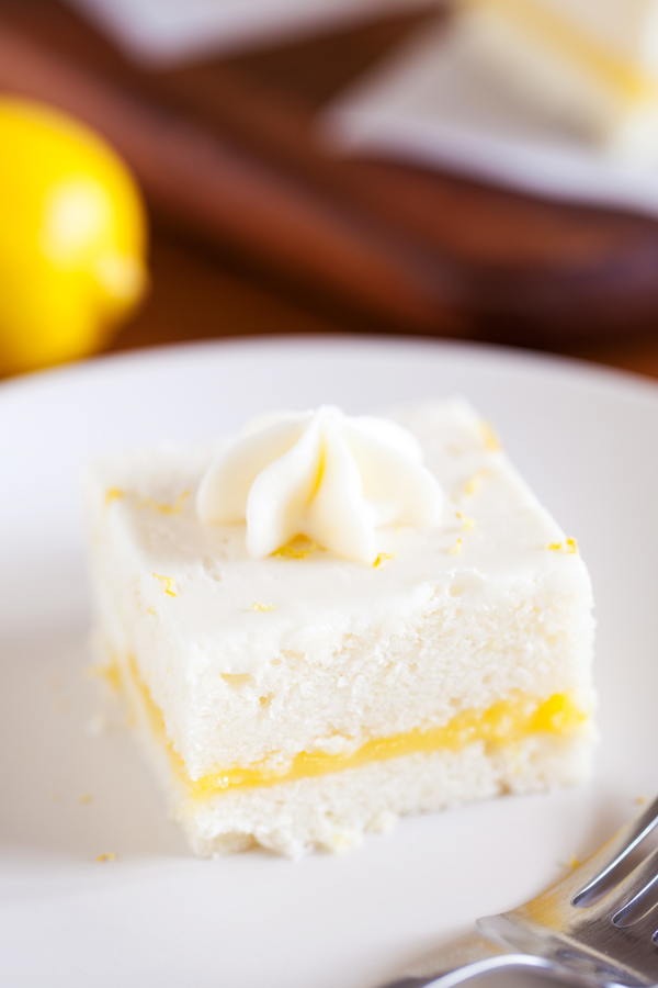 Two layers of soft white cake, lemon curd filling, and cream cheese frosting make this Lemon Snack Cake the perfect “light” and bright dessert.