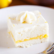 Two layers of soft white cake, lemon curd filling, and cream cheese frosting make this Lemon Snack Cake the perfect “light” and bright dessert.