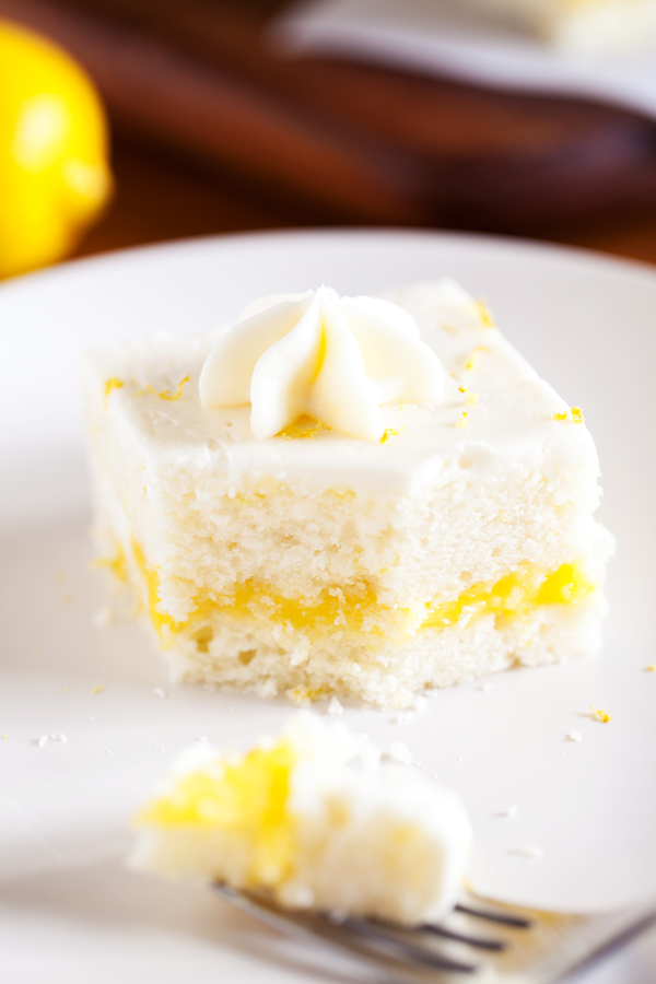 Two layers of soft white cake, lemon curd filling, and cream cheese frosting make this Lemon Snack Cake the perfect “light” and bright dessert.