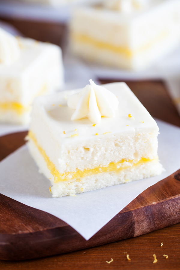 Two layers of soft white cake, lemon curd filling, and cream cheese frosting make this Lemon Snack Cake the perfect “light” and bright dessert.