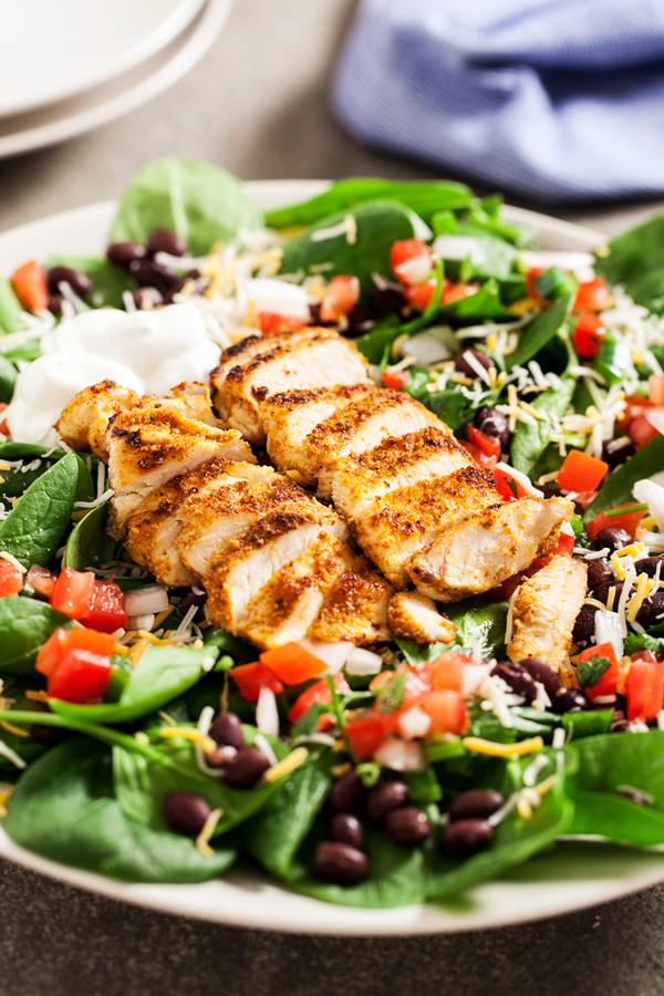 Chicken Spinach Taco Salad - Juicy and perfectly seasoned chicken served on a bed of fresh spinach leaves and topped with black beans and homemade pico de gallo.