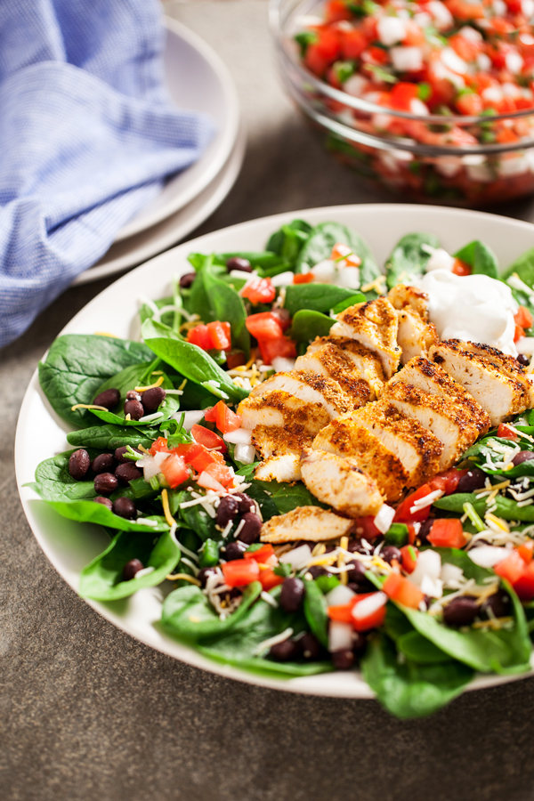 Chicken Spinach Taco Salad - Juicy and perfectly seasoned chicken served on a bed of fresh spinach leaves and topped with black beans and homemade pico de gallo.