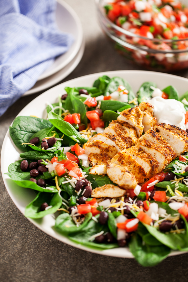 Chicken Spinach Taco Salad - Juicy and perfectly seasoned chicken served on a bed of fresh spinach leaves and topped with black beans and homemade pico de gallo.