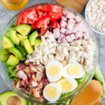 A Classic Cobb Salad loaded with fresh vegetables, three kinds of meat, hard boiled eggs, and blue cheese crumbles.