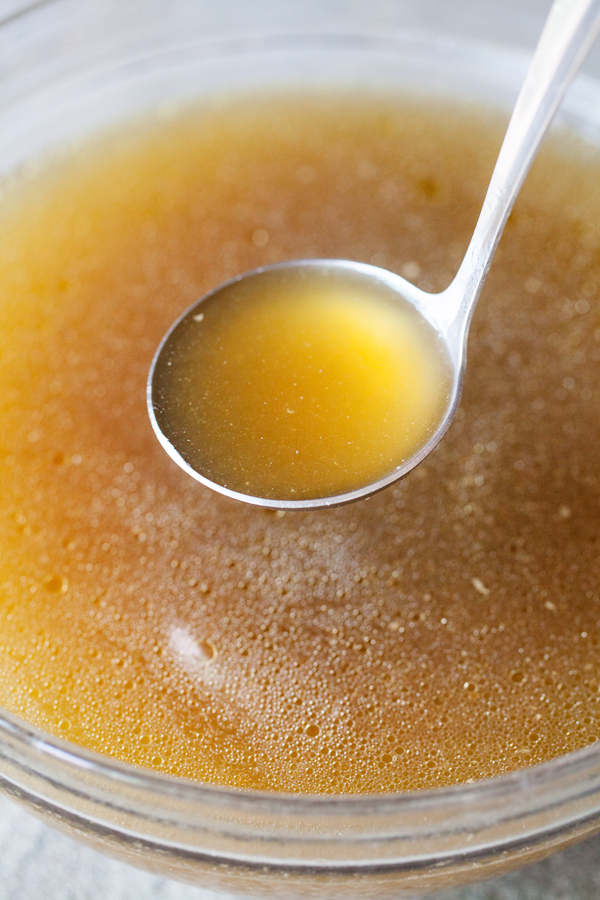 Chicken stock in a ladle. 