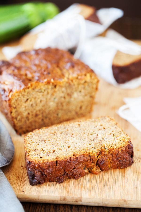 One slice of zucchini bread and loaf in the background. 