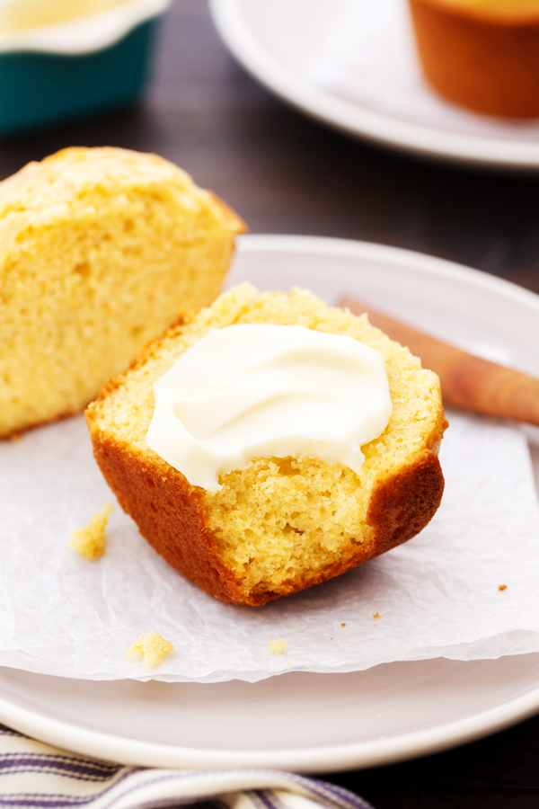 Bitten cornbread muffin with pat of butter. 