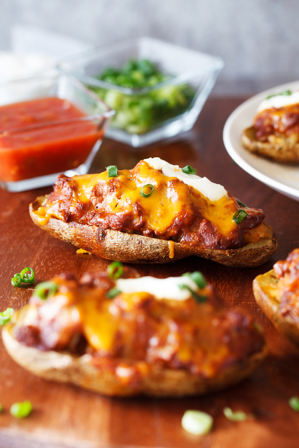 Chili Cheese Stuffed Potato Skins consist of an entire russet potato half, are loaded with a hefty filling, and finished off with mouthwatering toppings.