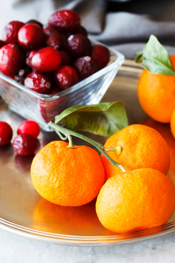 Fresh cranberries and tangerines on a platter. 