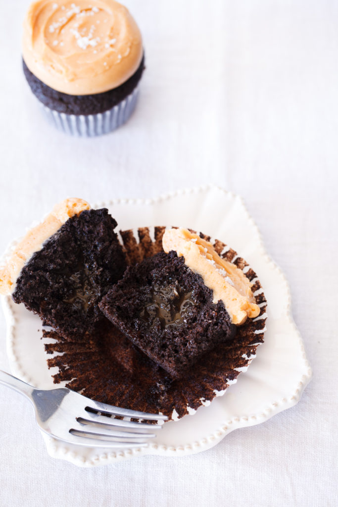 Chocolate cupcake with dulce de leche frosting split open. 