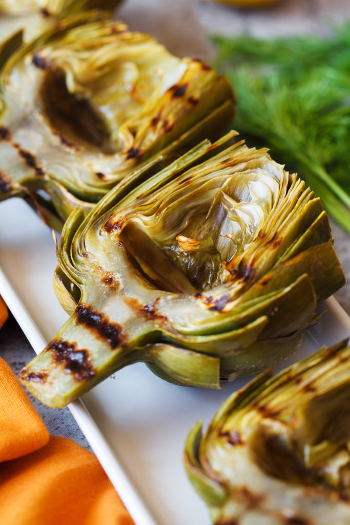Grilled artichokes on a platter.