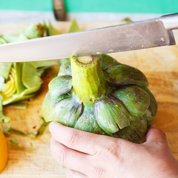 Halving an artichoke from the stem. 