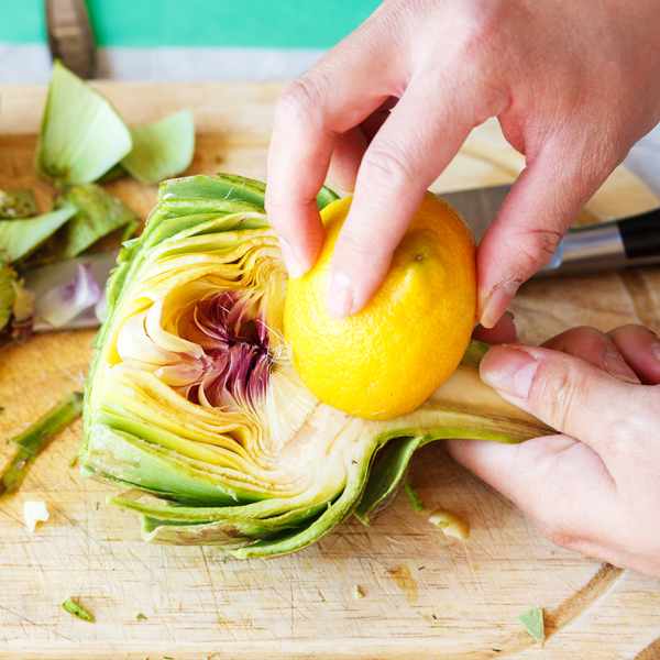 Rubbing of a lemon onto the inside of a cut artichoke. 