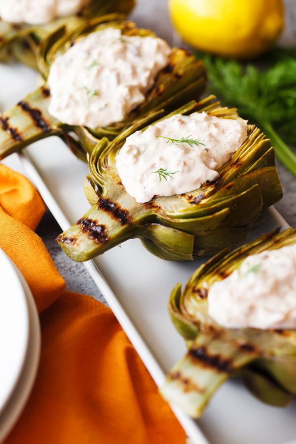 Tuna stuffed grilled artichokes on a platter. 