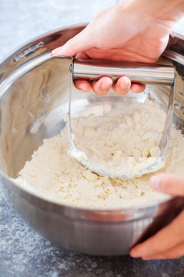 Hand cutting butter with flour. 