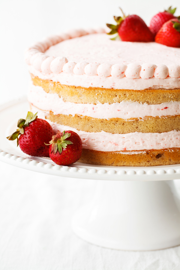 3-layer fresh strawberry cake on cake stand.