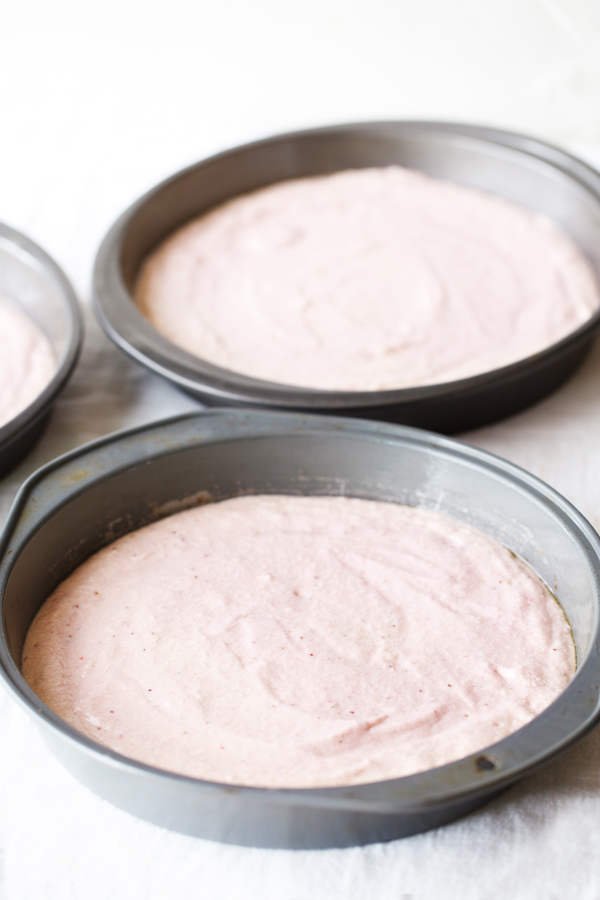 Raw cake batter in three round cake pans