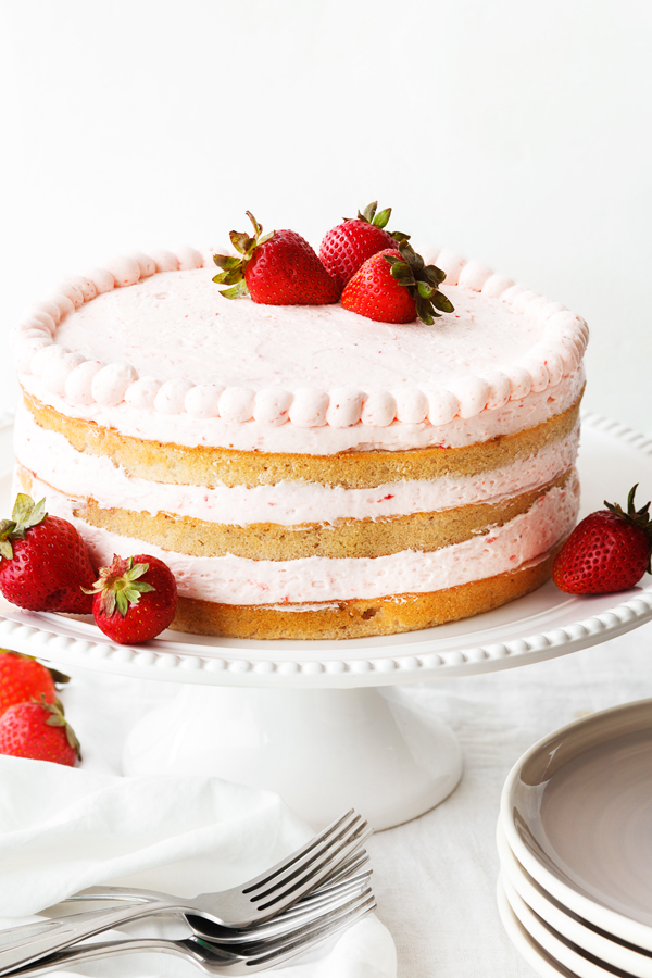 3-layer fresh strawberry cake on cake stand.