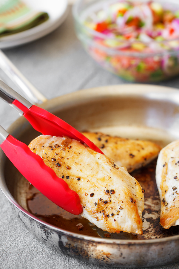 Cooked breast fillet on skillet for chicken with avocado salsa