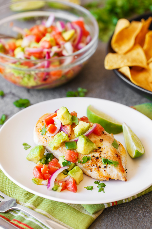 Chicken with avocado salsa on a plate. 