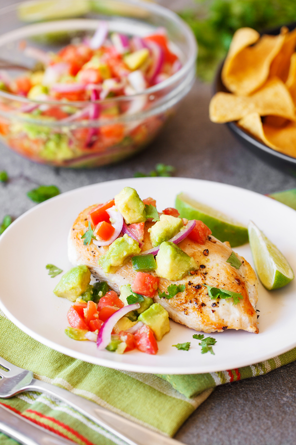 Chicken with avocado salsa on a plate. 