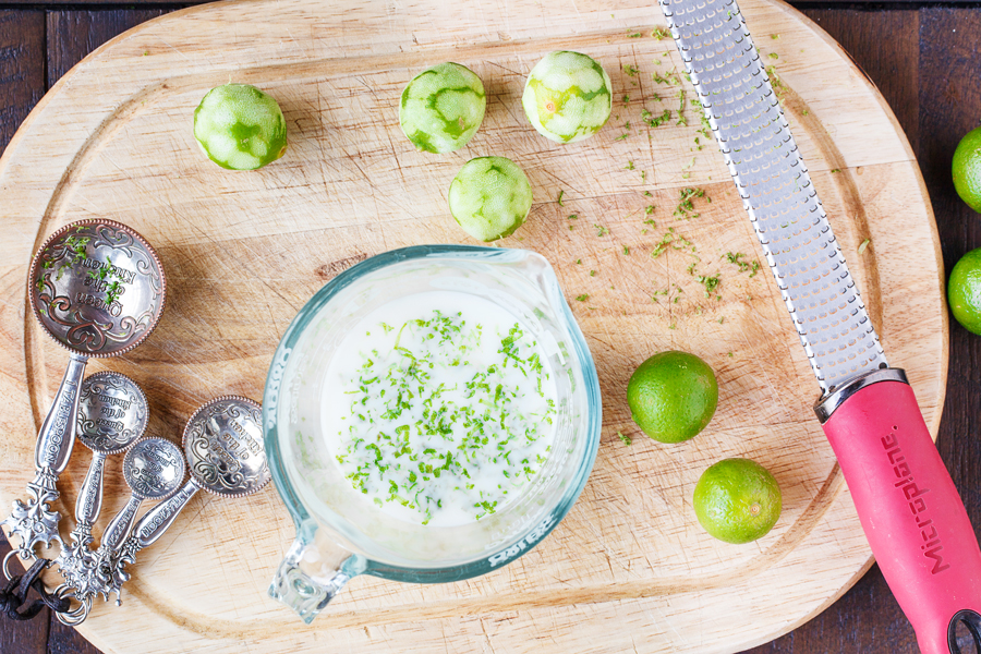 Birds eye view of zested key limes and key lime zest in milk. 