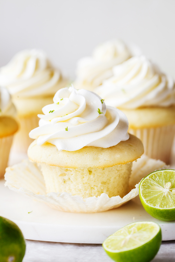 Key lime cupcake topped with key lime buttercream with cupcake liner peeled off.