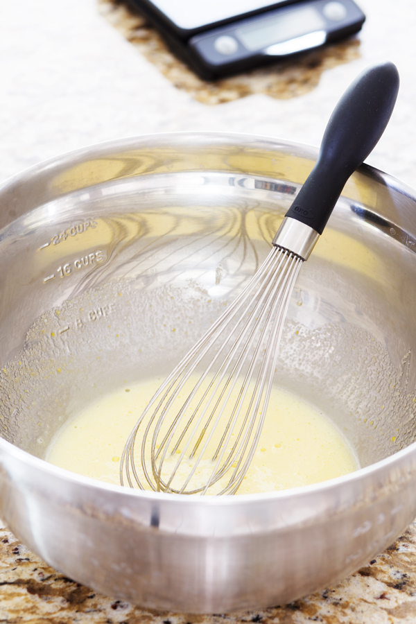 Preparation step for Swedish Visiting Cake Bars - egg batter in a bowl with whisk.