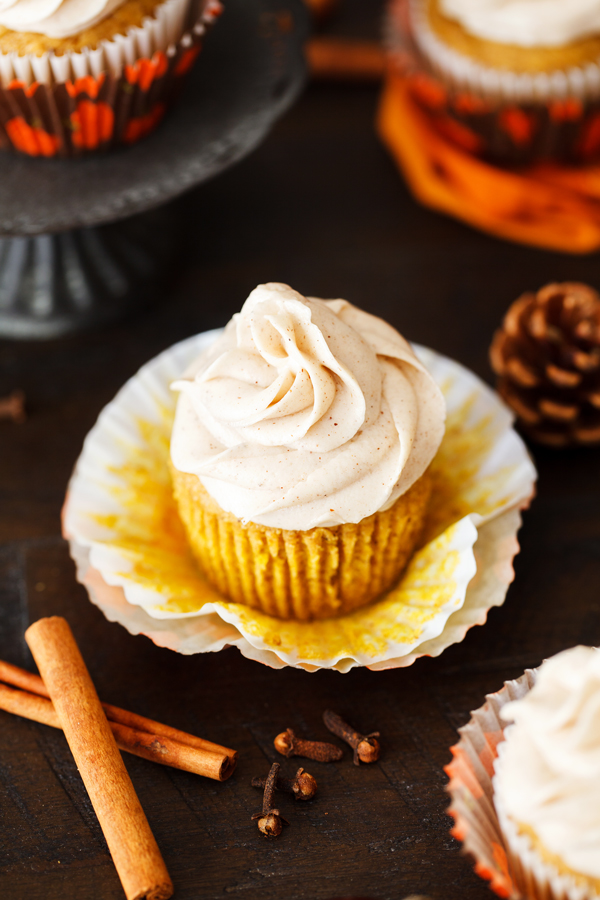 Pumpkin spice cupcake with cinnamon cream cheese frosting with wrapper removed.