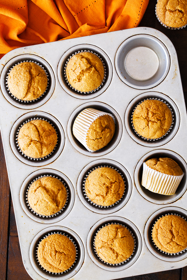 Preparation step for pumpkin spice cupcakes - baked cupcakes in muffin tray.