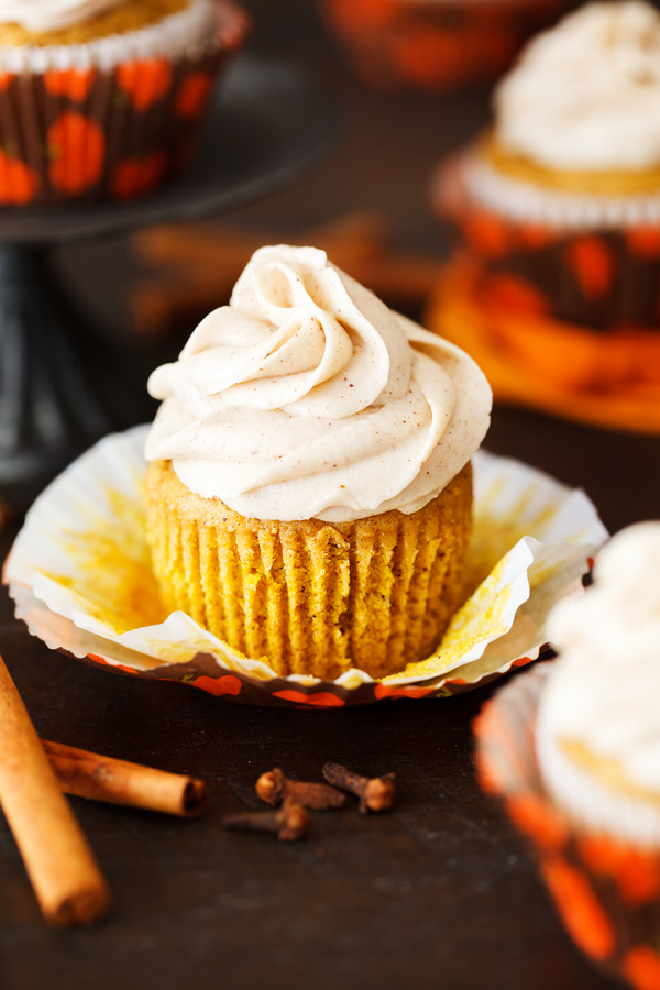 Pumpkin spice cupcake with cinnamon cream cheese frosting with wrapper removed.
