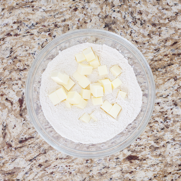 Preparation step for flakey all-butter pie crust - butter cubes and flour in bowl