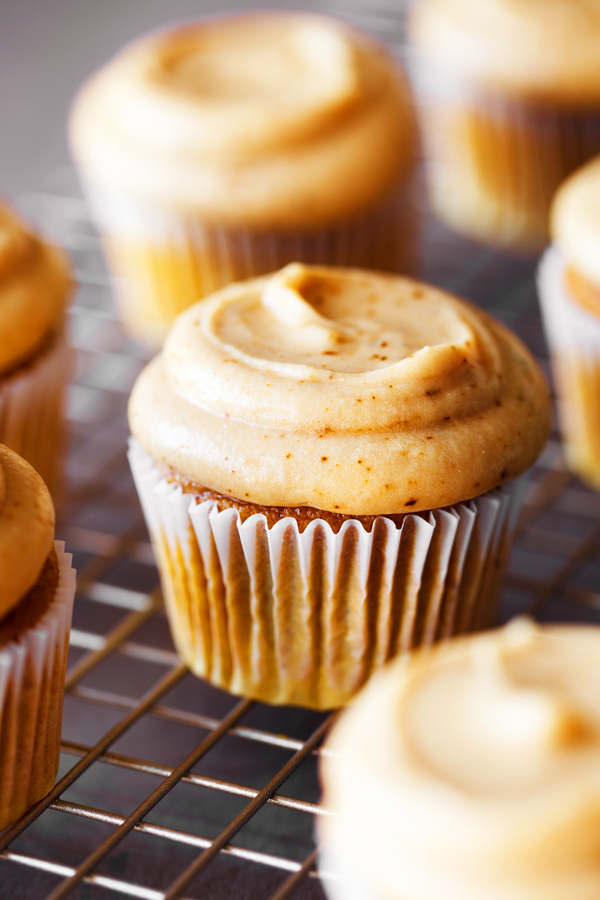 Pumpkin spice latte cupcakes on cooling rack.