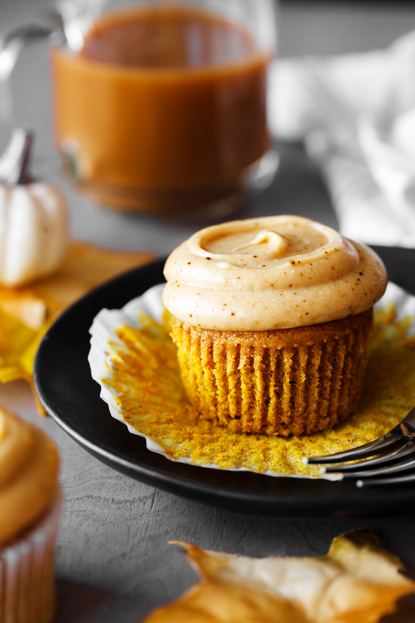 Pumpkin spice latte cupcake with liner removed on a plate.