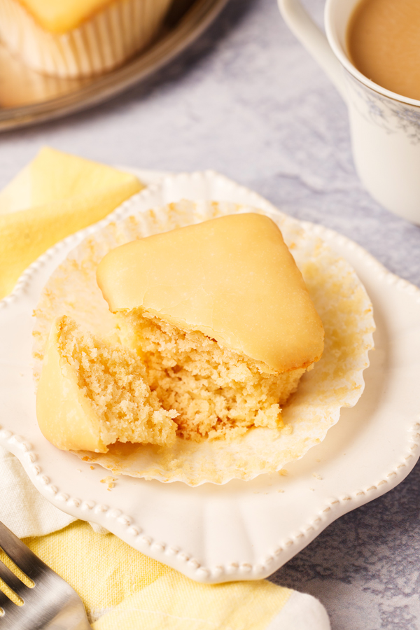 Martino's Bakery original tea cake on serving plate, unwrapped from liner, with piece sliced off. 