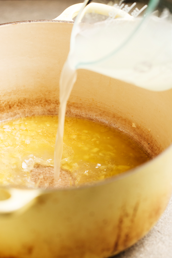 Preparation step for One Pot Pasta with Lemon Garlic Butter Sauce - pasta water being poured into pot