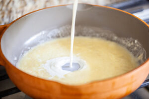 Milk being added to roux